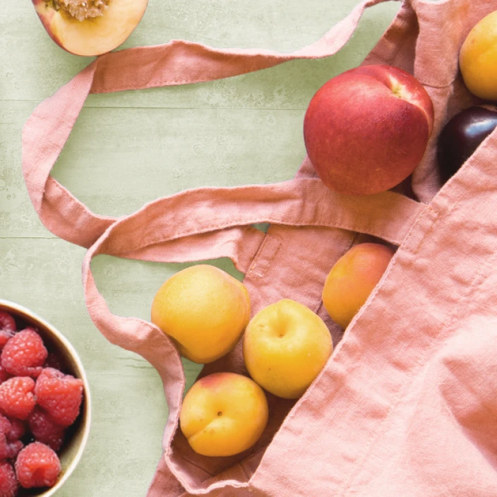 A pink grocery bag full of fresh fruit